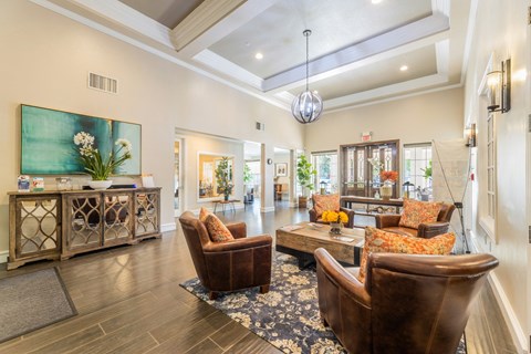 Waiting area with leather seats and a coffee table at the entrance to the leasing office at Encore at Buckingham apartments in Richardson, TX